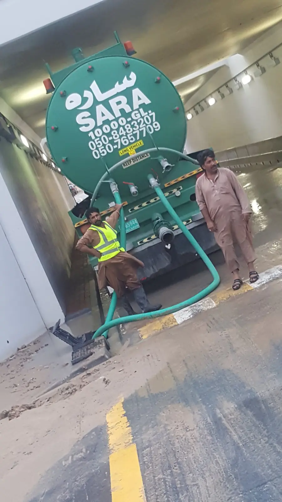 Sara General Land Transport 10,000 gallon tanker truck crew pumping water from a Dubai underpass